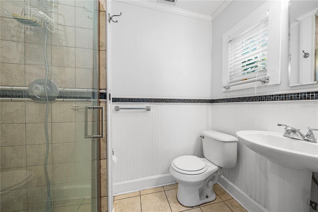 bathroom with walk in shower, crown molding, toilet, and tile patterned floors