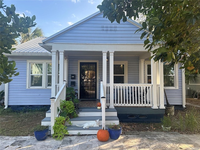 doorway to property with covered porch and metal roof