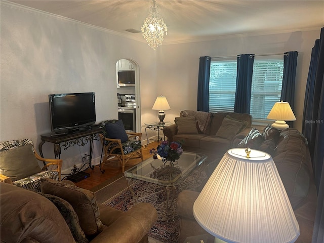 living room with visible vents, an inviting chandelier, wood finished floors, and crown molding