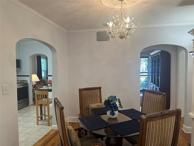 dining room featuring visible vents, plenty of natural light, crown molding, and baseboards