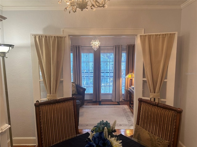 foyer featuring an inviting chandelier, a textured wall, and ornamental molding