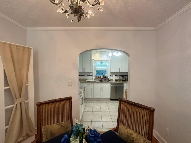 kitchen with arched walkways, a sink, crown molding, and stainless steel dishwasher