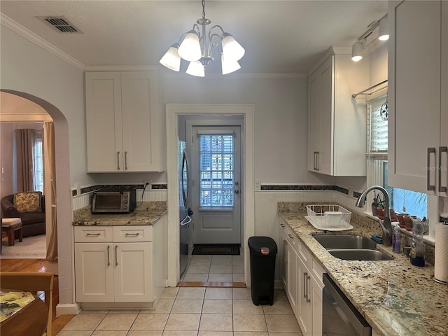 kitchen featuring visible vents, a sink, arched walkways, crown molding, and dishwasher