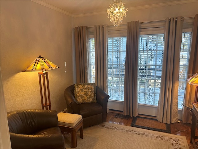 sitting room with wood finished floors, an inviting chandelier, and ornamental molding