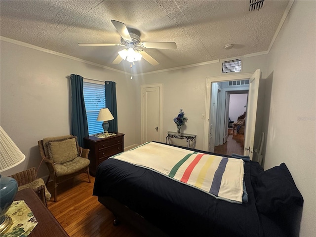 bedroom featuring a textured ceiling, wood finished floors, and crown molding