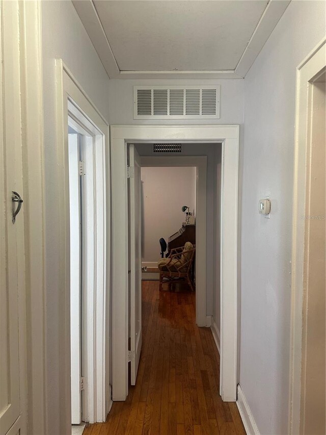 corridor featuring visible vents and wood finished floors