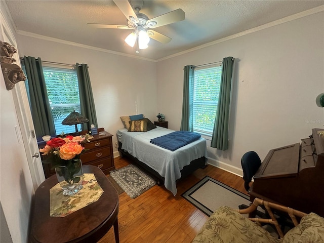 bedroom featuring multiple windows, wood finished floors, and crown molding