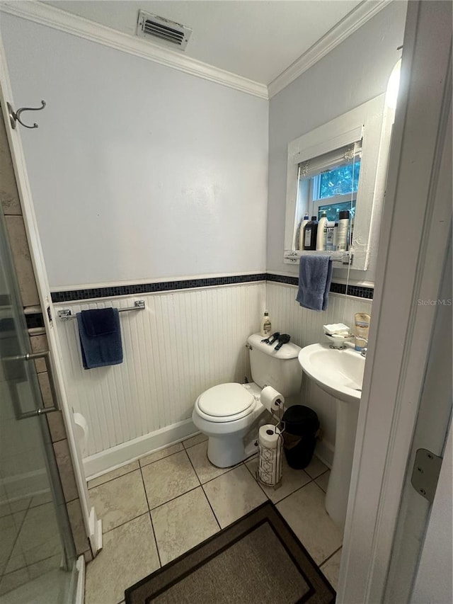 full bathroom featuring visible vents, a wainscoted wall, ornamental molding, a shower stall, and toilet