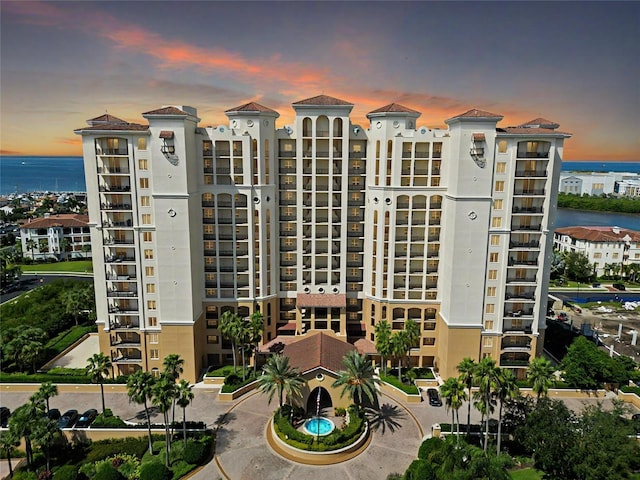 property at dusk featuring a water view