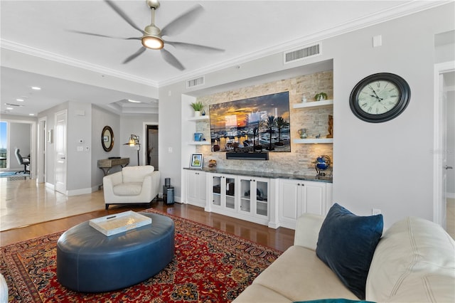 living room with ornamental molding, hardwood / wood-style floors, and ceiling fan