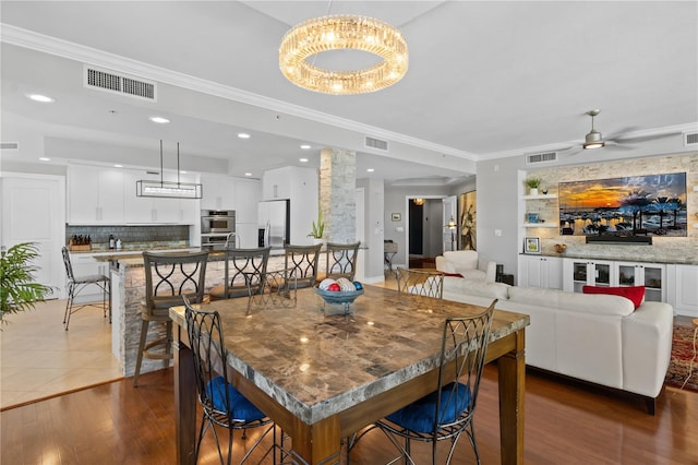 dining room featuring crown molding, dark hardwood / wood-style flooring, and ceiling fan with notable chandelier