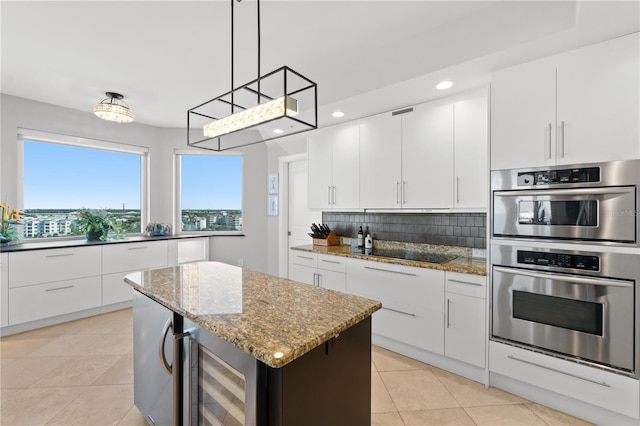 kitchen featuring a center island, double oven, hanging light fixtures, white cabinets, and wine cooler