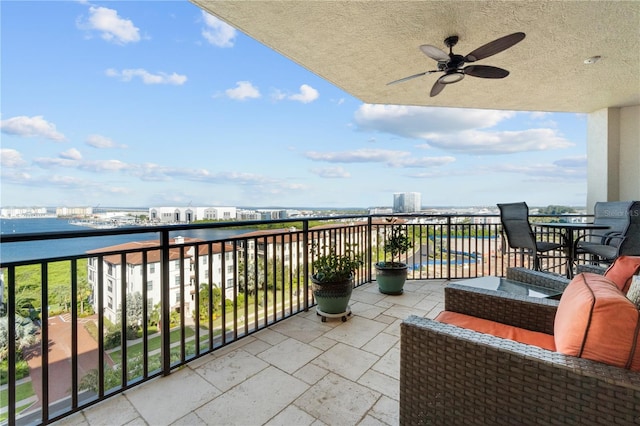 balcony featuring a water view and ceiling fan