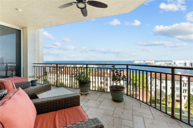 balcony with a water view and ceiling fan