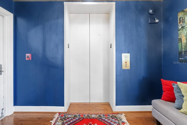 foyer entrance with hardwood / wood-style floors and elevator