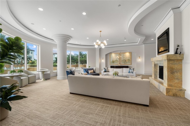 carpeted living room featuring a premium fireplace, a chandelier, and a tray ceiling