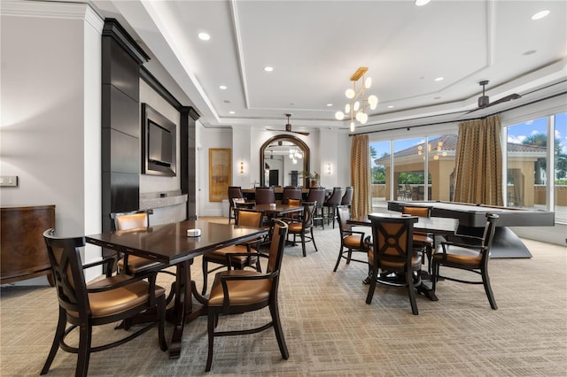 carpeted dining area with ornamental molding, a chandelier, and a raised ceiling