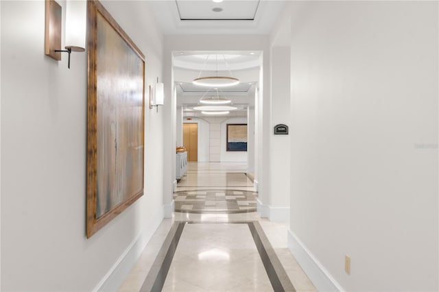 hall featuring ornamental molding and a tray ceiling