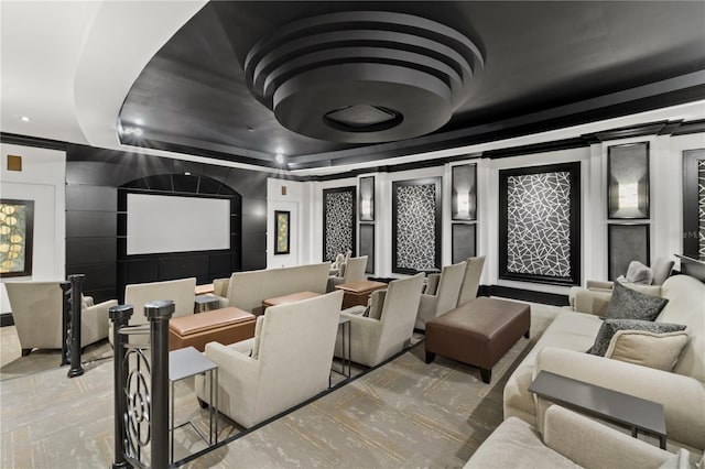 home theater room featuring ornamental molding and a tray ceiling