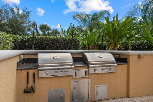 view of patio featuring an outdoor kitchen and a grill