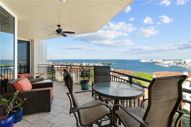 balcony featuring a water view and ceiling fan