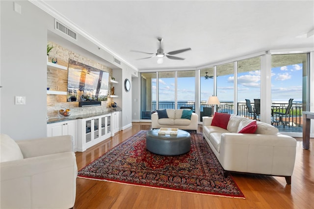 living room with wood-type flooring, plenty of natural light, and floor to ceiling windows