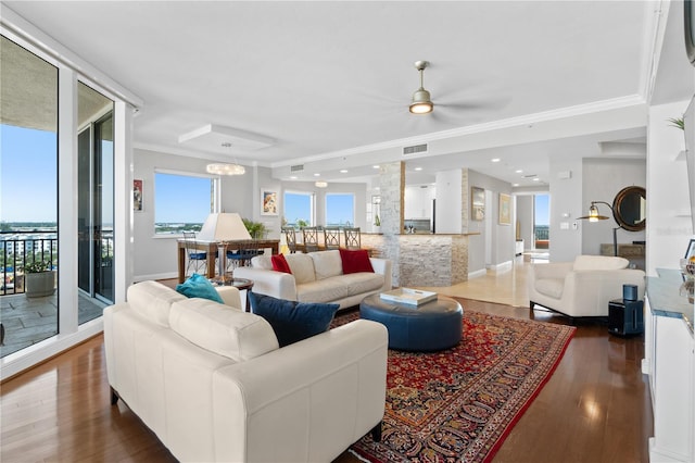 living room with crown molding, dark hardwood / wood-style flooring, and ceiling fan with notable chandelier