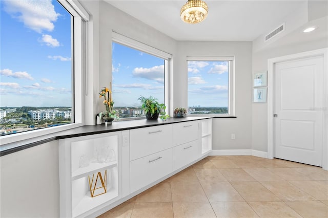 kitchen with white cabinets, light tile patterned floors, and a wealth of natural light