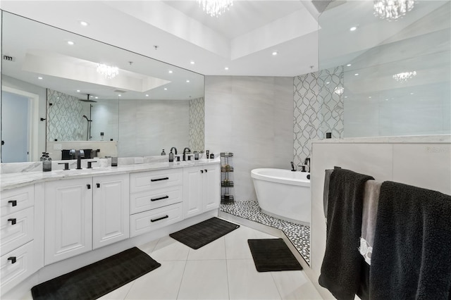 bathroom with tile patterned floors, independent shower and bath, a tray ceiling, tile walls, and vanity