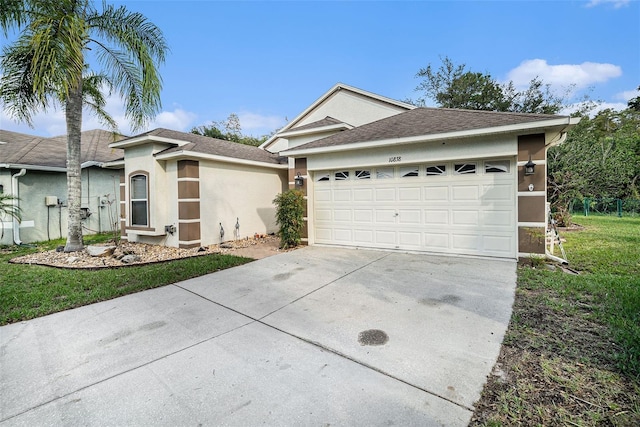 ranch-style home with a garage and a front lawn