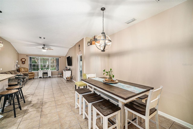 tiled dining space with ceiling fan with notable chandelier and vaulted ceiling