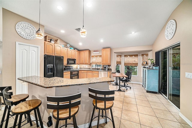 kitchen with pendant lighting, light tile patterned floors, vaulted ceiling, black appliances, and a kitchen bar