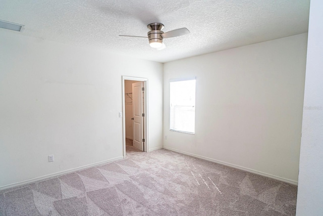 carpeted empty room featuring a textured ceiling and ceiling fan