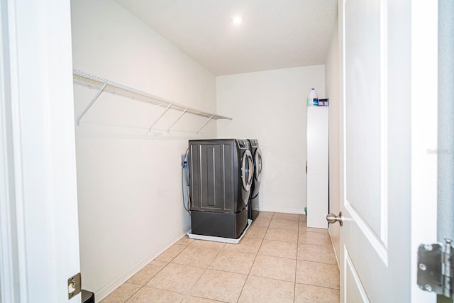 clothes washing area featuring light tile patterned flooring and independent washer and dryer