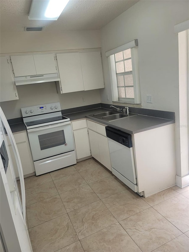 kitchen with a textured ceiling, sink, white cabinets, white appliances, and light tile patterned floors