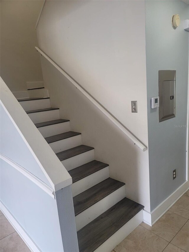 stairway with tile patterned flooring and electric panel