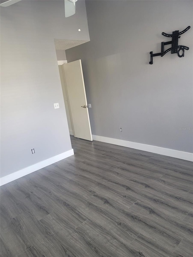 unfurnished room with dark wood-type flooring