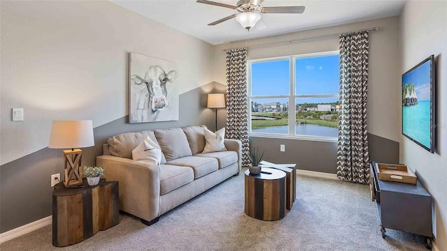 carpeted living room featuring a water view and ceiling fan