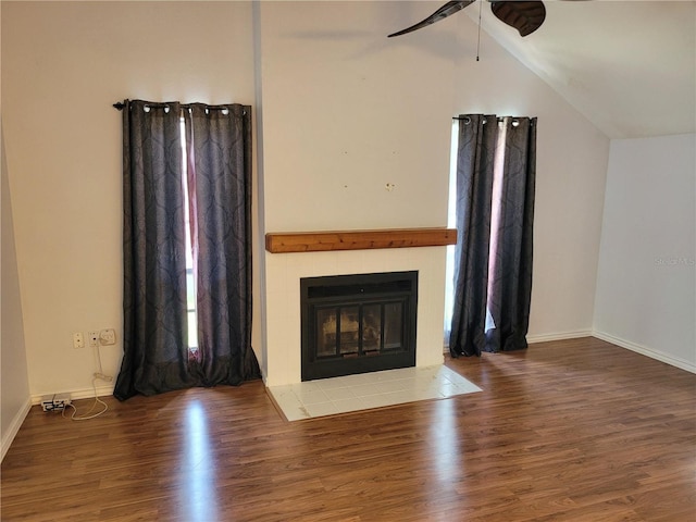 unfurnished living room with wood-type flooring, vaulted ceiling, ceiling fan, and a fireplace