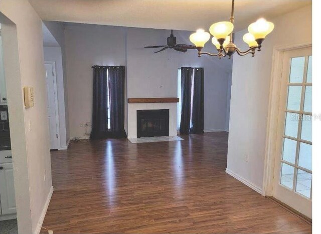 10908 Claymont Dr, New Port Richey, FL 34654 - unfurnished living room with a chandelier, plenty of natural light, wood finished floors, and baseboards