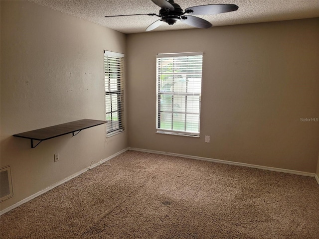 spare room featuring ceiling fan, carpet floors, and a textured ceiling