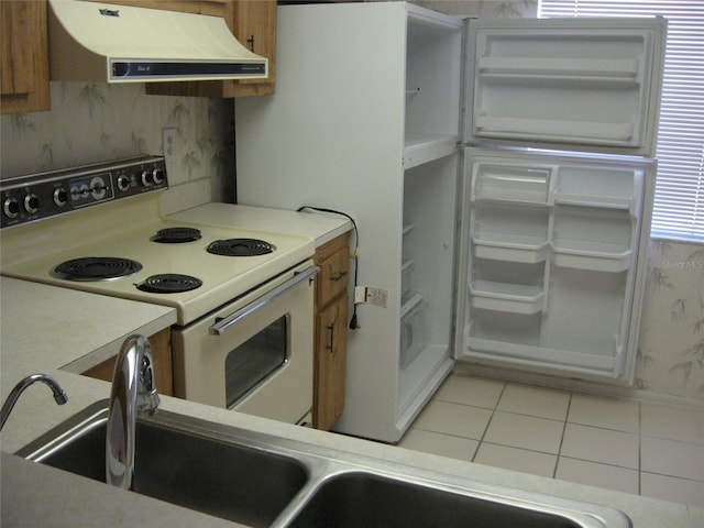 kitchen with white electric range oven, light countertops, light tile patterned flooring, and range hood