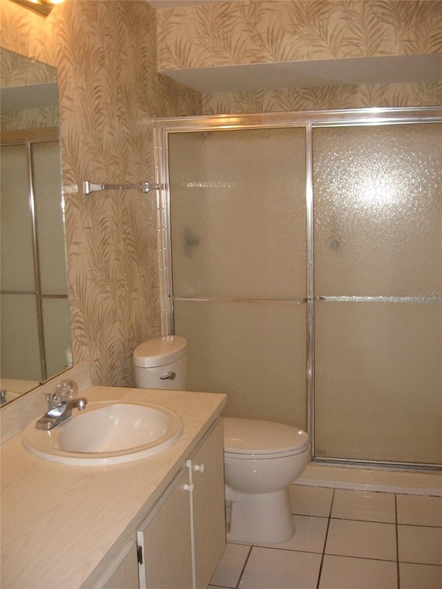 bathroom with vanity, toilet, tile patterned floors, and an enclosed shower