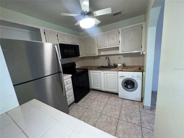 kitchen featuring ceiling fan, sink, black appliances, washer / clothes dryer, and tile counters