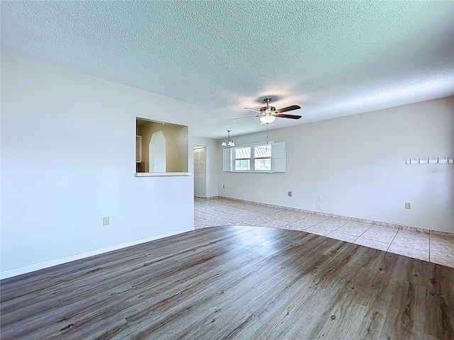 11920 Boynton Ln Unit 11920, New Port Richey, FL 34654 - empty room featuring wood finished floors, a textured ceiling, baseboards, and ceiling fan