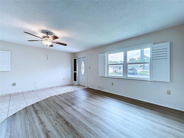 11920 Boynton Ln Unit 11920, New Port Richey, FL 34654 - unfurnished living room featuring baseboards, a ceiling fan, wood finished floors, and a textured ceiling