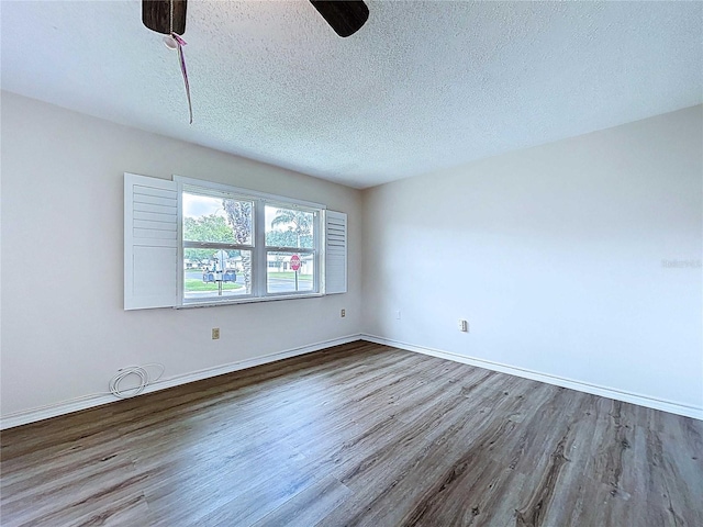 11920 Boynton Ln Unit 11920, New Port Richey, FL 34654 - unfurnished room with baseboards, a ceiling fan, wood finished floors, and a textured ceiling