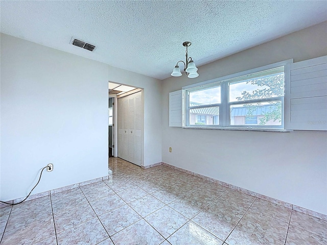 11920 Boynton Ln Unit 11920, New Port Richey, FL 34654 - empty room featuring a textured ceiling, baseboards, visible vents, a chandelier, and light tile patterned floors