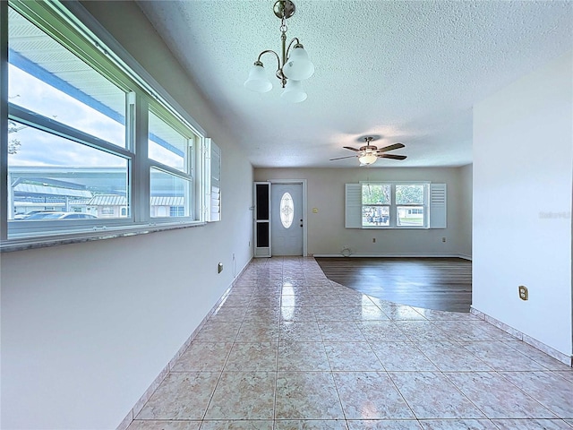 11920 Boynton Ln Unit 11920, New Port Richey, FL 34654 - entryway with ceiling fan with notable chandelier, tile patterned floors, baseboards, and a textured ceiling