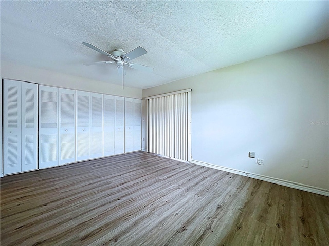 11920 Boynton Ln Unit 11920, New Port Richey, FL 34654 - unfurnished bedroom with baseboards, a ceiling fan, wood finished floors, and a textured ceiling